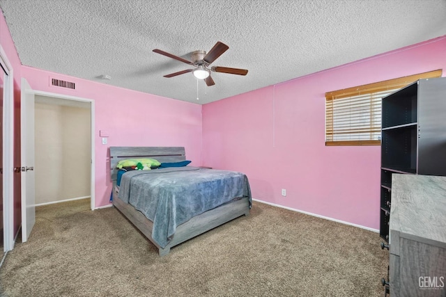 carpeted bedroom with baseboards, a ceiling fan, visible vents, and a textured ceiling