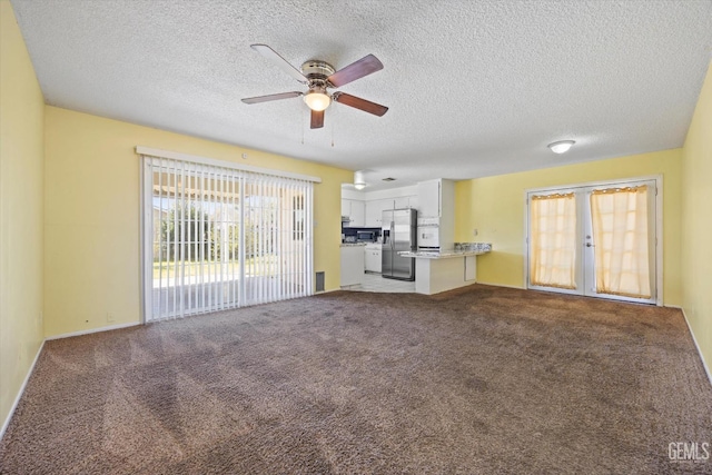 unfurnished living room with carpet, a textured ceiling, french doors, and a ceiling fan