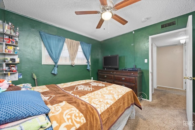 bedroom with carpet, visible vents, a textured wall, and a textured ceiling