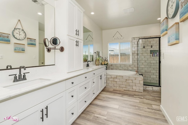 802 Barre Ct, Bakersfield, CA 93314 - full bathroom featuring double vanity, a garden tub, a stall shower, recessed lighting, and wood finished floors