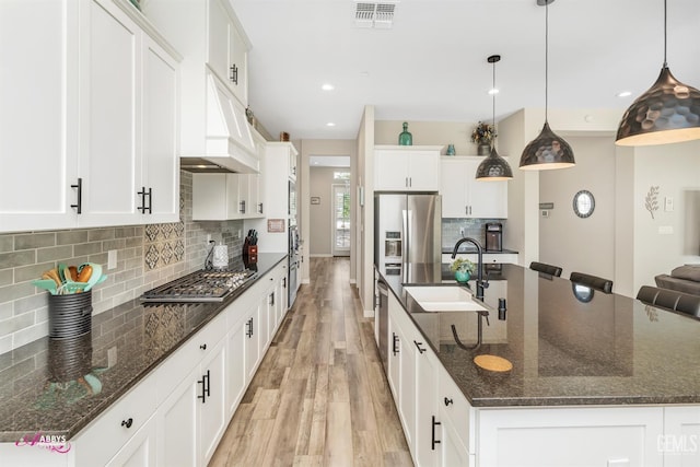 802 Barre Ct, Bakersfield, CA 93314 - kitchen with stainless steel appliances, light wood finished floors, a spacious island, tasteful backsplash, and white cabinets