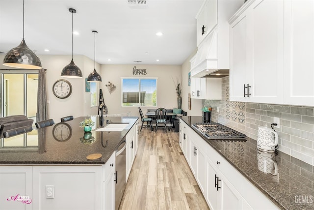 802 Barre Ct, Bakersfield, CA 93314 - kitchen featuring stainless steel appliances, light wood-style flooring, an island with sink, decorative backsplash, and white cabinets