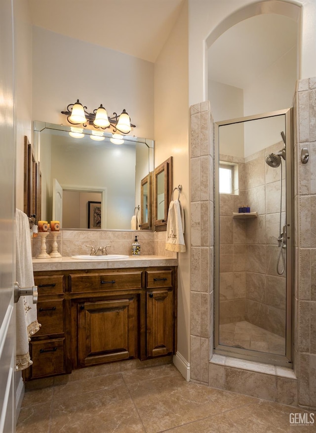 bathroom featuring tasteful backsplash, vanity, and a shower stall