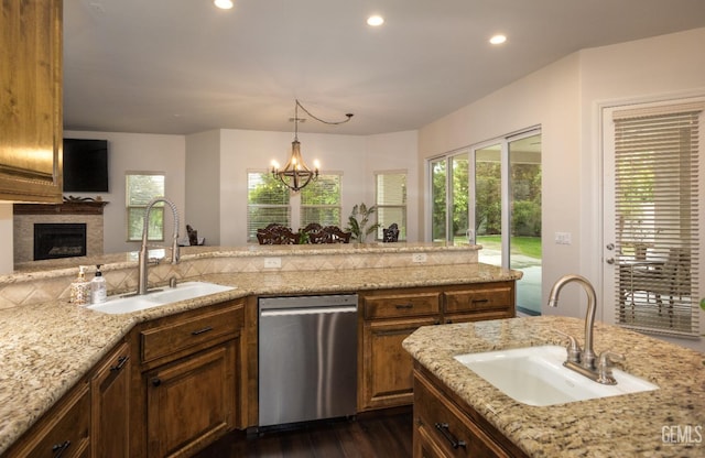 kitchen featuring a sink, light stone countertops, dishwasher, and dark wood-style flooring