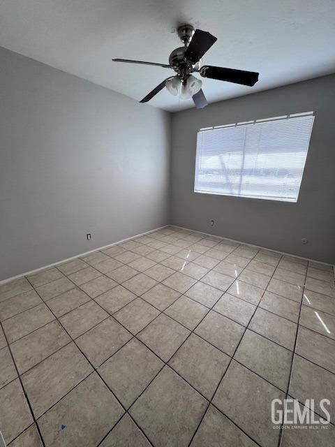 spare room featuring light tile patterned floors and ceiling fan