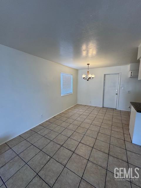 unfurnished dining area with light tile patterned flooring and a chandelier