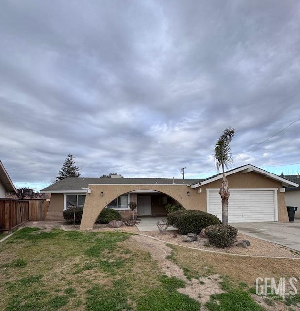 ranch-style home featuring a garage and a front lawn