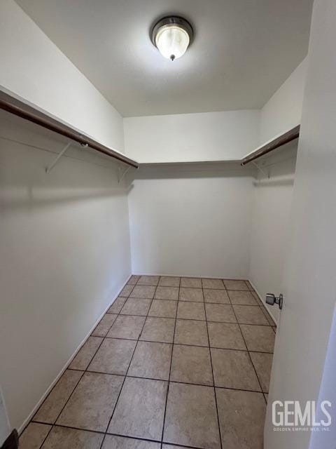 spacious closet with light tile patterned floors