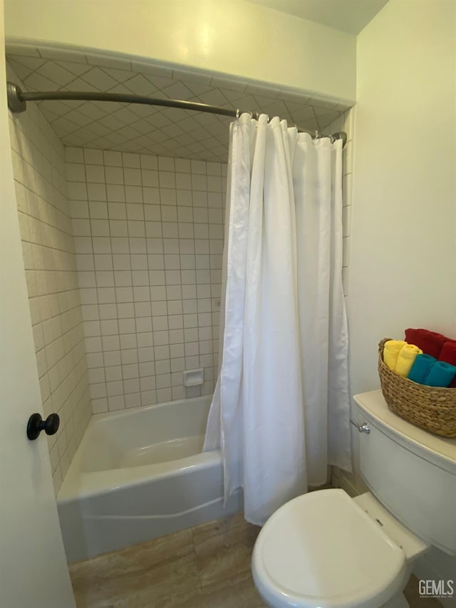 bathroom featuring shower / tub combo and toilet