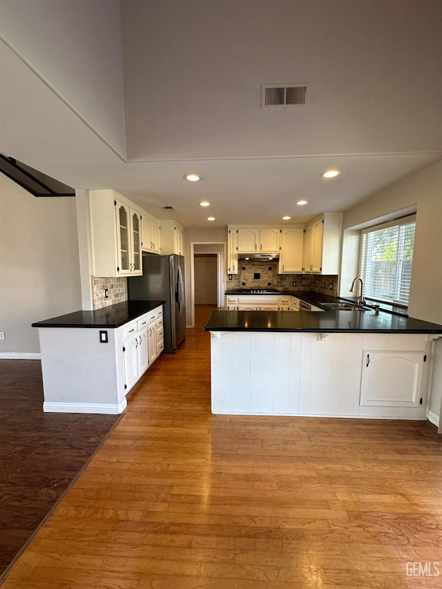 kitchen with white cabinetry, light wood-type flooring, and kitchen peninsula