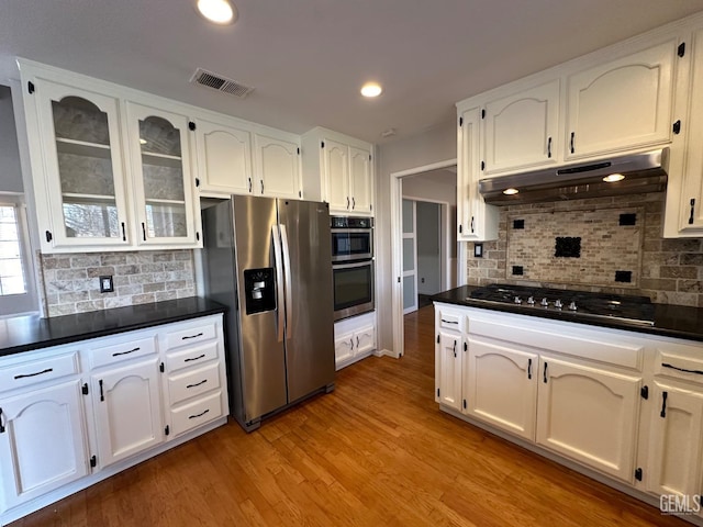 kitchen with white cabinetry, decorative backsplash, light hardwood / wood-style flooring, and appliances with stainless steel finishes