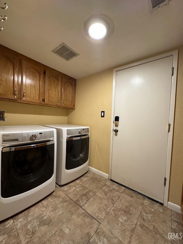 washroom featuring cabinets and washing machine and clothes dryer