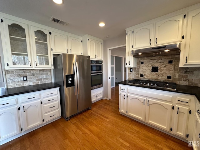 kitchen featuring appliances with stainless steel finishes, backsplash, light hardwood / wood-style floors, and white cabinetry