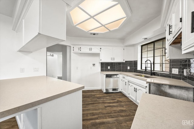 kitchen with dark wood-type flooring, a sink, backsplash, white cabinetry, and white dishwasher