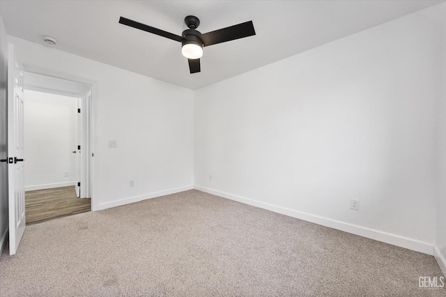 carpeted empty room with baseboards and ceiling fan