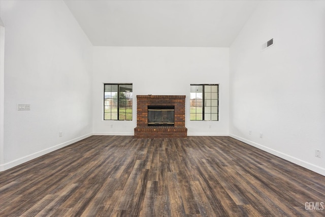 unfurnished living room with visible vents, baseboards, high vaulted ceiling, and dark wood finished floors