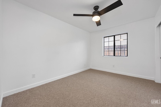 spare room with baseboards, a ceiling fan, and carpet