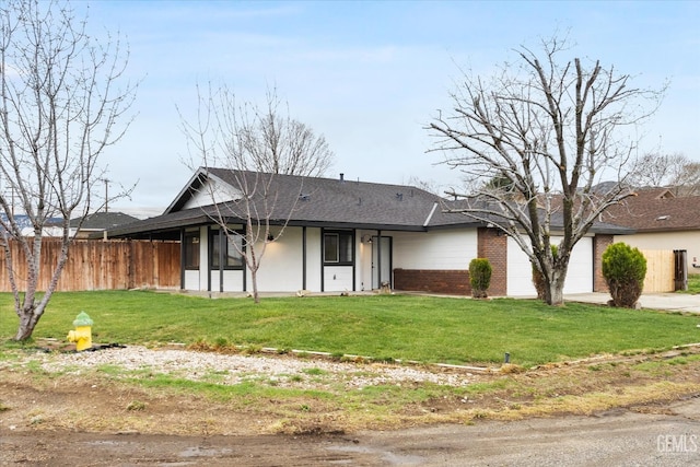 view of front of home featuring a garage, roof with shingles, a front lawn, and fence