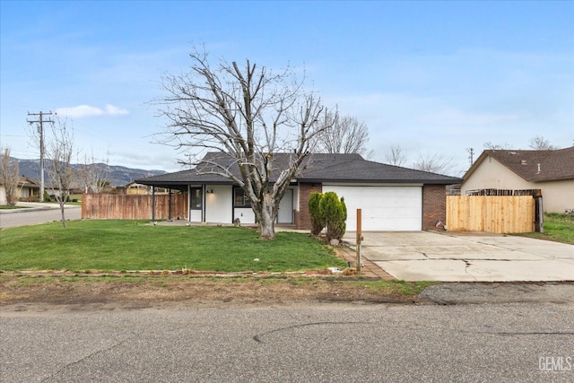 view of front of home featuring a front yard, concrete driveway, a garage, and fence