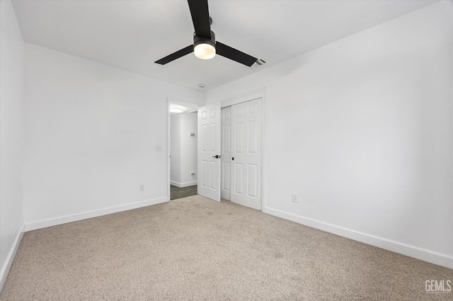 unfurnished bedroom with a closet, ceiling fan, baseboards, and carpet