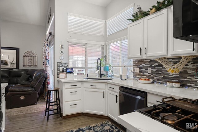 5000 Rogue Water Ct, Bakersfield, CA 93313 - kitchen featuring dishwashing machine, dark wood-type flooring, decorative backsplash, white cabinetry, and a towering ceiling