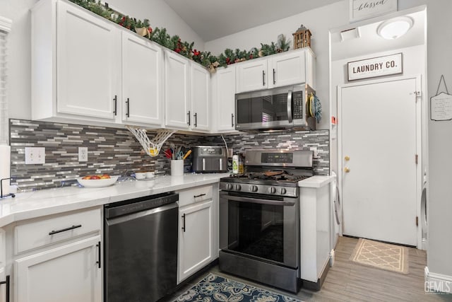 5000 Rogue Water Ct, Bakersfield, CA 93313 - kitchen featuring appliances with stainless steel finishes, backsplash, white cabinets, and light wood-type flooring