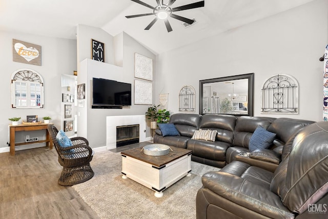 5000 Rogue Water Ct, Bakersfield, CA 93313 - living area featuring a ceiling fan, wood finished floors, a tile fireplace, and high vaulted ceiling