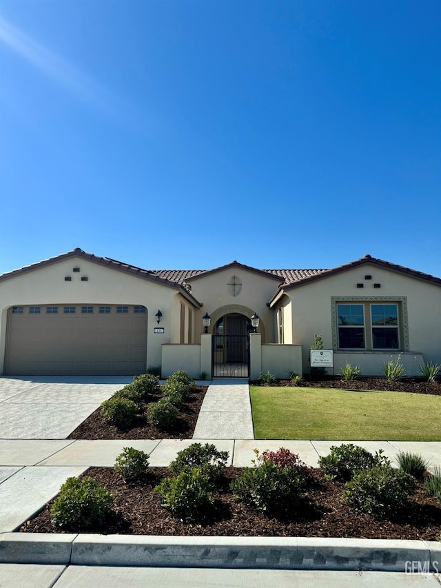 mediterranean / spanish home with decorative driveway, stucco siding, an attached garage, a front yard, and a tiled roof