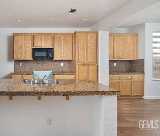 5400 Saddleback Ridge Ct, Bakersfield, CA 93313 - kitchen featuring black microwave, a kitchen bar, decorative backsplash, dark wood finished floors, and recessed lighting