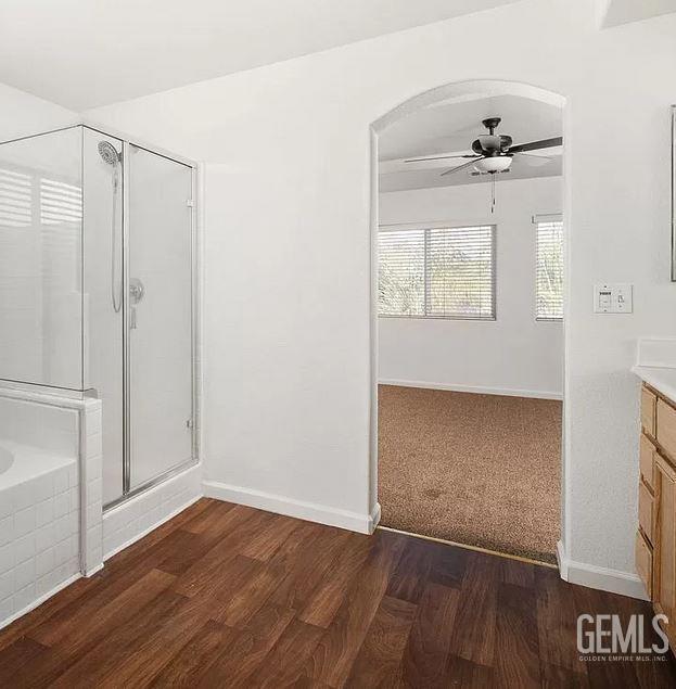 5400 Saddleback Ridge Ct, Bakersfield, CA 93313 - bathroom with ceiling fan, vanity, a stall shower, a bath, and wood finished floors