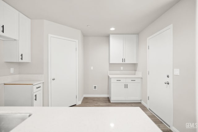 618 Poinsettia St, Bakersfield, CA 93307 - kitchen with light wood-style floors, white cabinets, light countertops, and recessed lighting