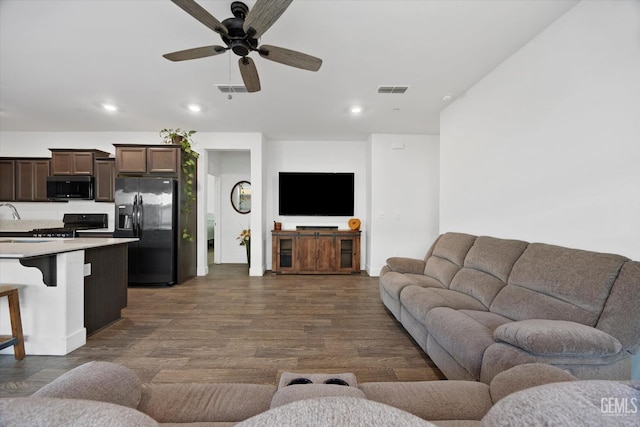 living room featuring visible vents, ceiling fan, baseboards, recessed lighting, and dark wood-type flooring