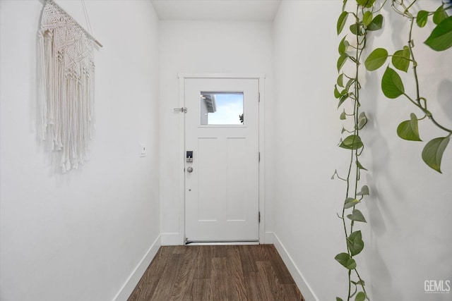 doorway with baseboards and wood finished floors