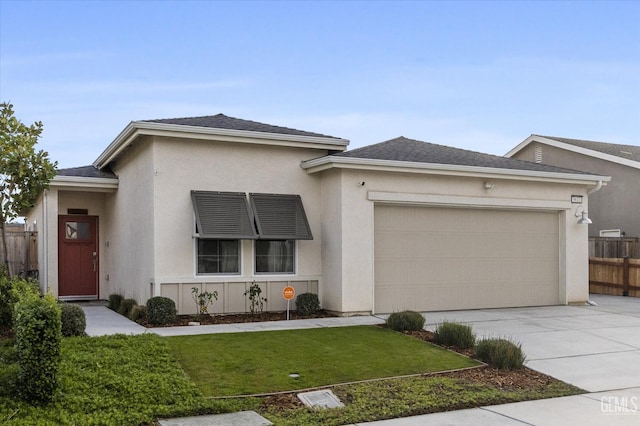 view of front of property featuring a front yard, an attached garage, driveway, stucco siding, and fence