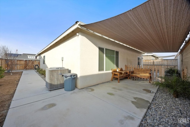 rear view of property featuring a patio, a fenced backyard, cooling unit, and stucco siding