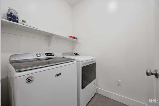 laundry room featuring light tile patterned flooring, washing machine and clothes dryer, laundry area, and baseboards