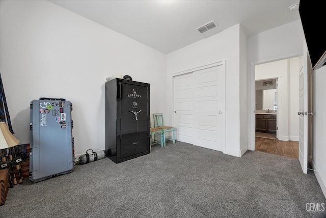 bedroom with a sink, a closet, visible vents, carpet, and baseboards