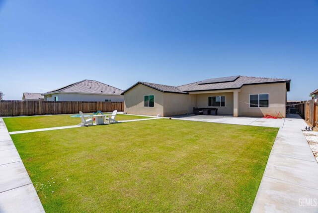 1215 Brookline Ln, Bakersfield, CA 93314 - rear view of house with a patio, roof mounted solar panels, and stucco siding