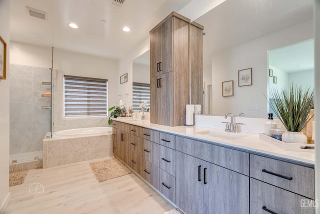 1215 Brookline Ln, Bakersfield, CA 93314 - bathroom featuring a garden tub, double vanity, a tile shower, wood finished floors, and recessed lighting