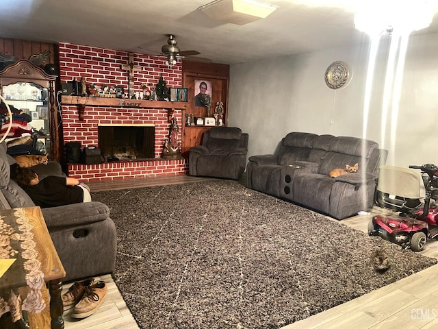 living room featuring a brick fireplace, hardwood / wood-style floors, and ceiling fan