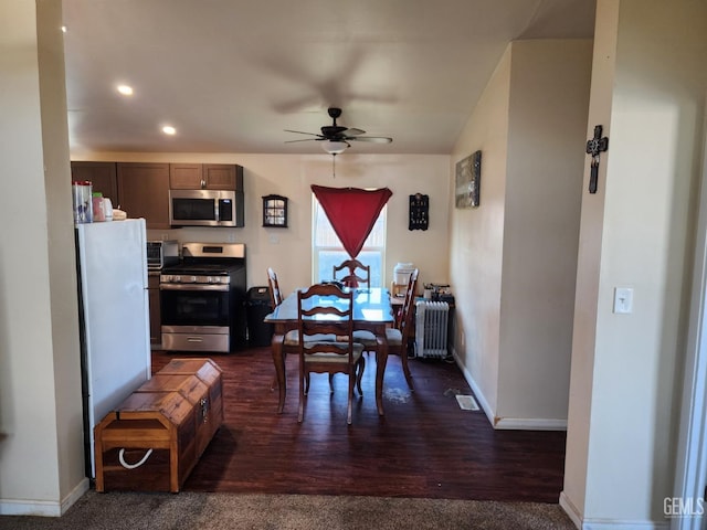 dining space featuring dark hardwood / wood-style flooring, radiator heating unit, and ceiling fan