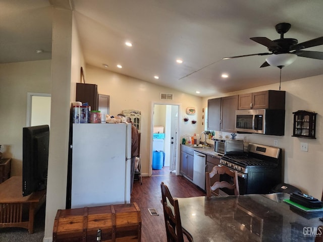 kitchen featuring lofted ceiling, sink, dark hardwood / wood-style flooring, stainless steel appliances, and light stone countertops