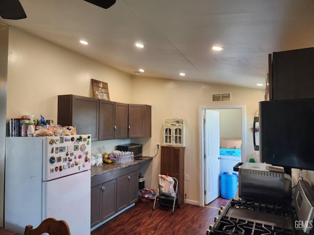 kitchen with lofted ceiling, dark brown cabinets, dark hardwood / wood-style floors, and white fridge