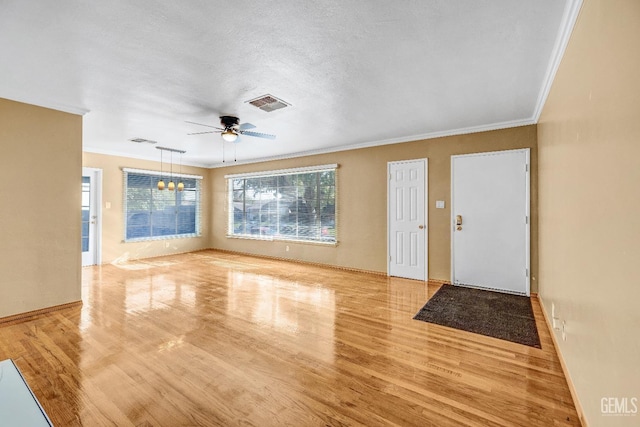 interior space featuring ceiling fan, light hardwood / wood-style floors, ornamental molding, and a textured ceiling