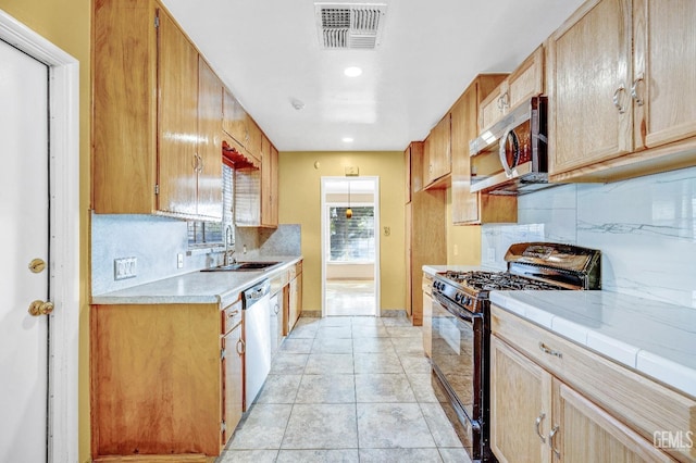 kitchen featuring tasteful backsplash, sink, light tile patterned floors, and stainless steel appliances