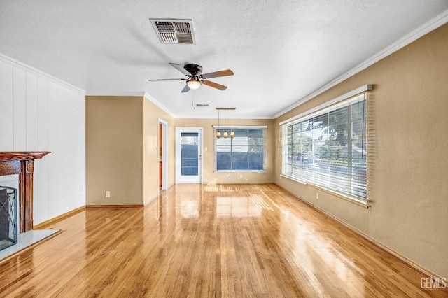 unfurnished living room featuring a textured ceiling, light hardwood / wood-style flooring, ceiling fan, and ornamental molding