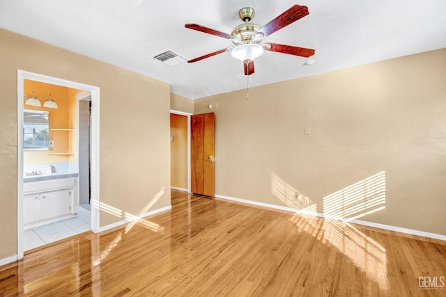 empty room with ceiling fan and light wood-type flooring