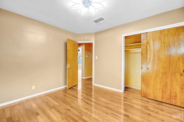 unfurnished bedroom with light wood-type flooring and a closet