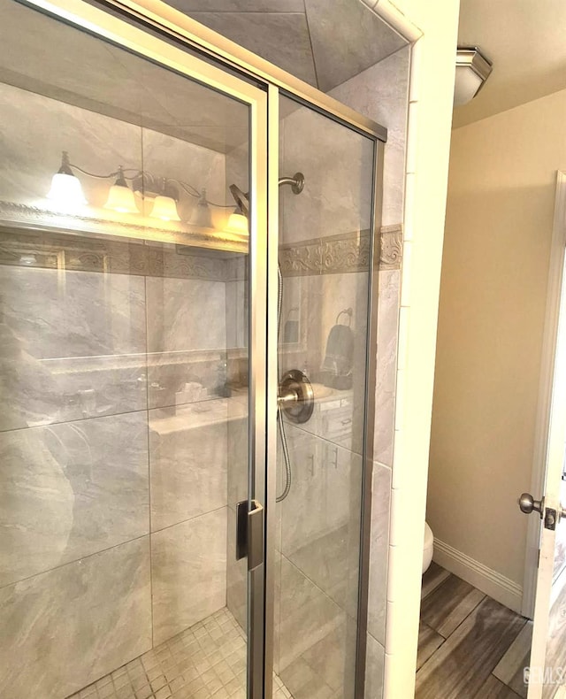 1109 Bell Ave, Taft, CA 93268 - bathroom with toilet, a stall shower, wood finished floors, and baseboards