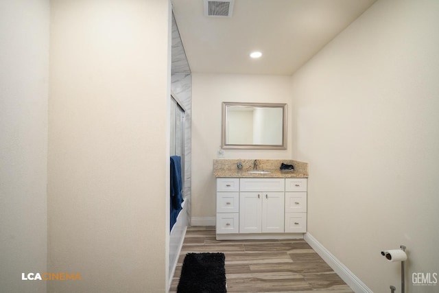 1109 Bell Ave, Taft, CA 93268 - full bathroom with wood finished floors, vanity, baseboards, shower / bathtub combination with curtain, and recessed lighting